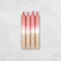 three pink and white candles sitting next to each other