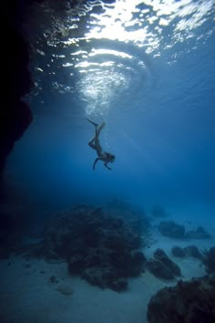 a person swimming in the ocean with their arms out and feet above water's surface