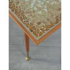 a table that has been decorated with gold and silver mosaic tiles on it's top