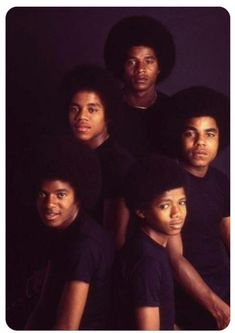 the jacksons posing for a group photo in front of a black background with their heads tilted