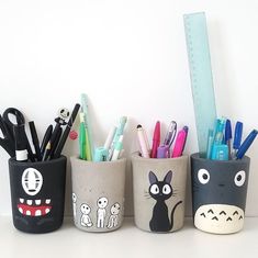 three pencil holders with different designs on them