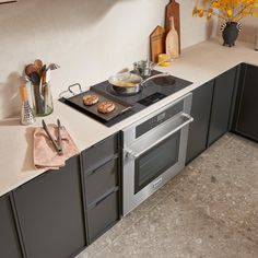 a stove top oven sitting inside of a kitchen next to a counter with utensils