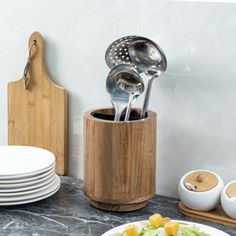 there is a plate with salad and utensils in it on the kitchen counter