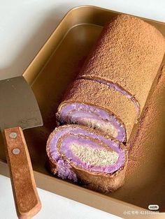 a loaf of cake with purple frosting and a knife