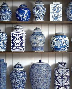 blue and white vases are lined up on shelves