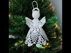 a crocheted angel ornament hanging from a christmas tree