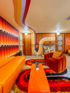 a living room with orange couches and colorful rugs