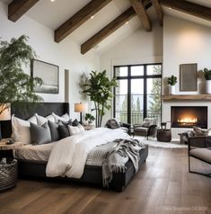 a large bed sitting in a bedroom next to a fire place on top of a hard wood floor