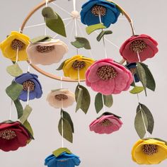 a multicolored flower mobile hanging from a wire