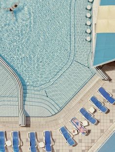 an overhead view of a swimming pool with lounge chairs