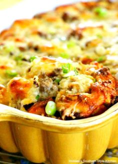 a casserole dish with meat, cheese and green onions in it on a table