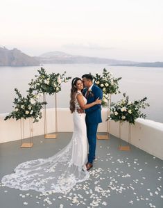 a bride and groom standing on a balcony with flowers