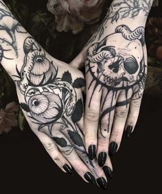 two hands with black and white tattoos on them