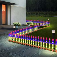 an outdoor garden with colorful lights on the grass