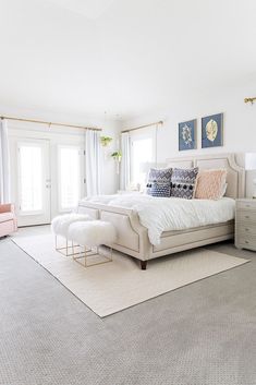 a bedroom with a bed, chair and rug