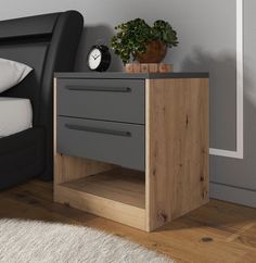 a nightstand with two drawers and a clock on top, next to a bed in a bedroom