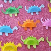 colorful paper plates shaped like dinosaurs on a pink background