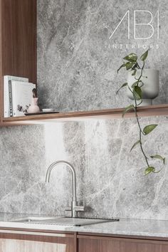 a kitchen with marble counter tops and wooden cabinets, along with a book shelf above the sink