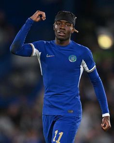 a man in blue uniform holding his fist up