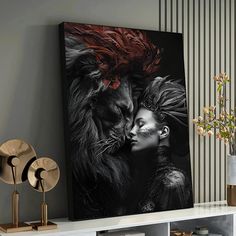 a black and white photo of two people kissing in front of a lion painting on a wall