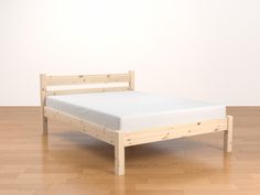 a wooden bed frame sitting on top of a hard wood floor next to a white wall