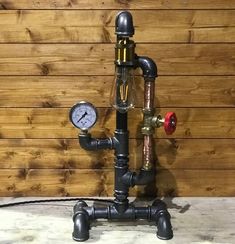 an old fashioned faucet is connected to a water meter on a wooden wall