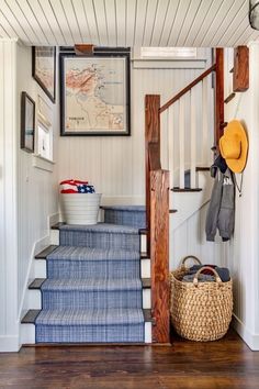 the stairs in this house are painted white and blue with wood trimmings, along with a basket