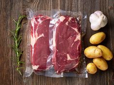 raw meat and potatoes laid out on a wooden table