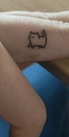 a small elephant tattoo on the left side of her right hand, with an arrow in the middle