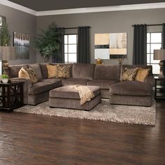 a living room filled with furniture and a large rug on top of a hard wood floor