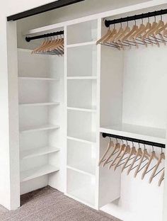 an organized closet with white shelving and wooden hangers