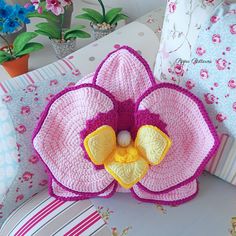 a crocheted flower sitting on top of pillows