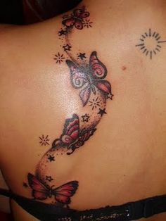 the back of a woman's stomach with butterflies on it and stars in the middle