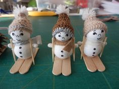 three small snowmen are sitting on sleds