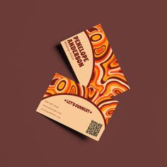 two business cards designed to look like an abstract pattern with orange and yellow swirls