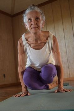 an older woman is doing yoga on a mat