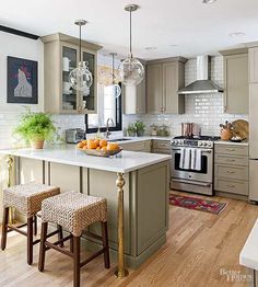 a kitchen with an island in the middle and two pictures on the wall above it