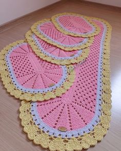 three crocheted placemats are on the floor