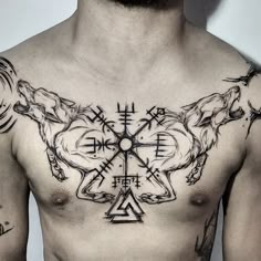 a man with tattoos on his chest has two wolfs in the middle of it