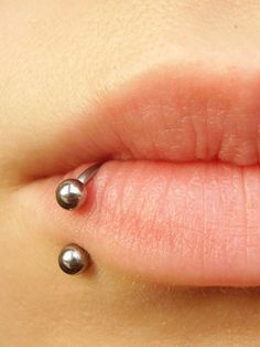 a woman's lip with three balls on it