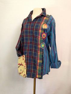 a plaid shirt with patches and buttons on the front is sitting on a mannequin's head