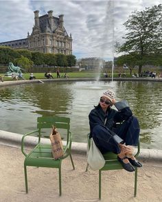 a person sitting on a chair in front of a fountain