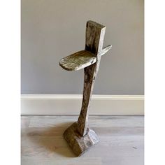 a wooden chair sitting on top of a hard wood floor next to a white wall