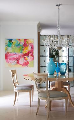 a dining room table with two chairs and a chandelier