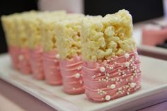 some kind of cake that is on a plate with pink icing and white sprinkles