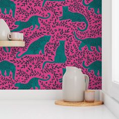 pink and blue wallpaper with dinosaurs on it in a white kitchen countertop next to two vases