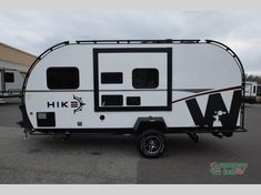 a white and black rv parked in a parking lot