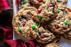 chocolate chip cookies with m & m candies and candy canes on a white plate