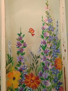 a painting of flowers and a butterfly on a wall