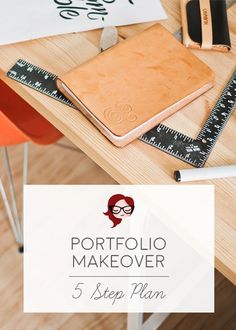 a wooden table topped with a notebook and ruler